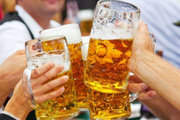 Four hands holding large glass steins of beer at Newport Oktoberfest