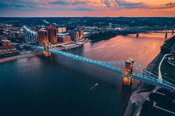 Sunset in the background over the Ohio river with the John A. Roebling Suspension bridge spanning from NKY to Cincy