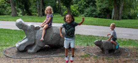 three children enjoying playing on concrete hippos at Florence nature park in Florence ky