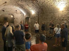 Image of people standing in an underground beer cellar.
