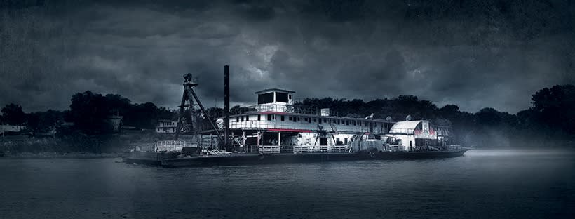 The USS Nightmare, a ship, is on the water, moodily lit, with fog and a clouded sky.