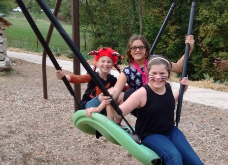 nature play at Behringer-Crawford Museum swing with three people on it