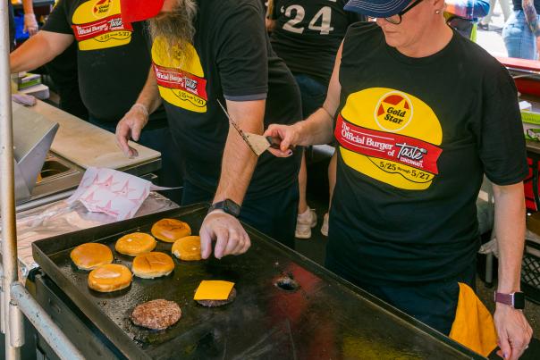 A crew at Taste of Cincinnati grill up some cheeseburgers.
