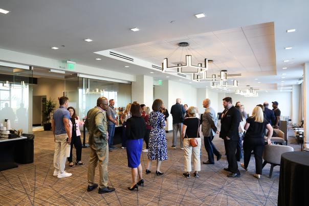 A group of event attendees mingle in a hotel event space.
