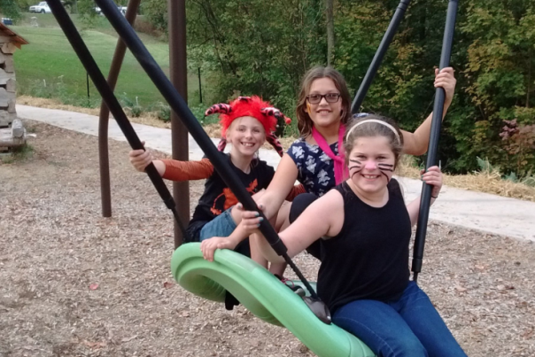 nature play at Behringer-Crawford Museum swing with three people on it