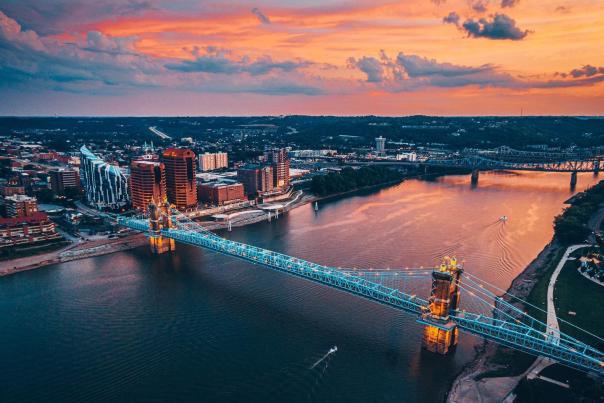 Sunset in the background over the Ohio river with the John A. Roebling Suspension bridge spanning from NKY to Cincy