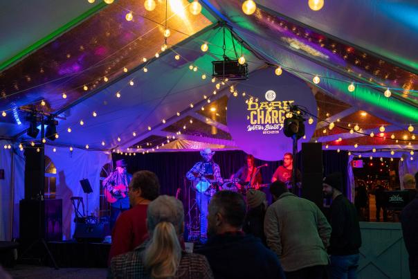 Musicians perform under glowing lights in a multitude of color.