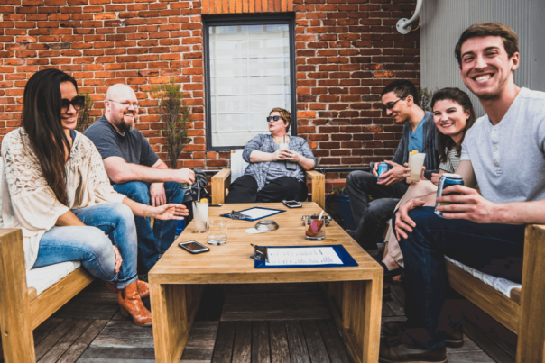 group of adults having cocktails at rooftop bar