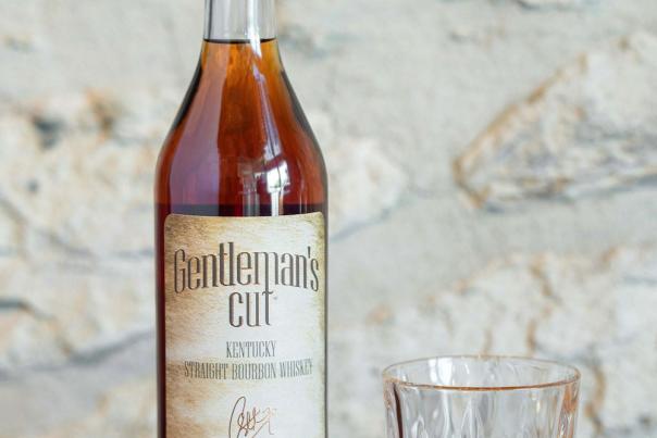 A bottle of NBA player Steph Curry's Gentleman's Cut bourbon sits next to a glass of the spirit