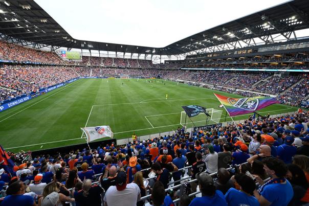 Fans wearing orange and blue sit inside the FC Cincinnati soccer stadium