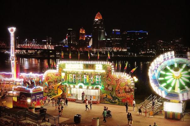dark skyline behind illuminated food stand and festival rides during italianfest at newport ky