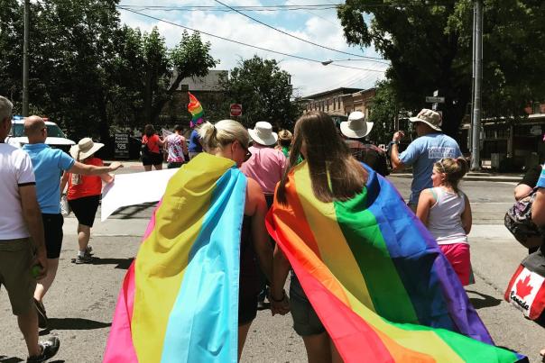 Two young people wearing Pride flags at NKY Pride in Covington Kentucky
