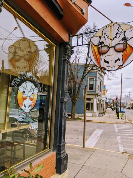Exterior sign and window of Elusive Cow restaurant in Bellevue, KY.