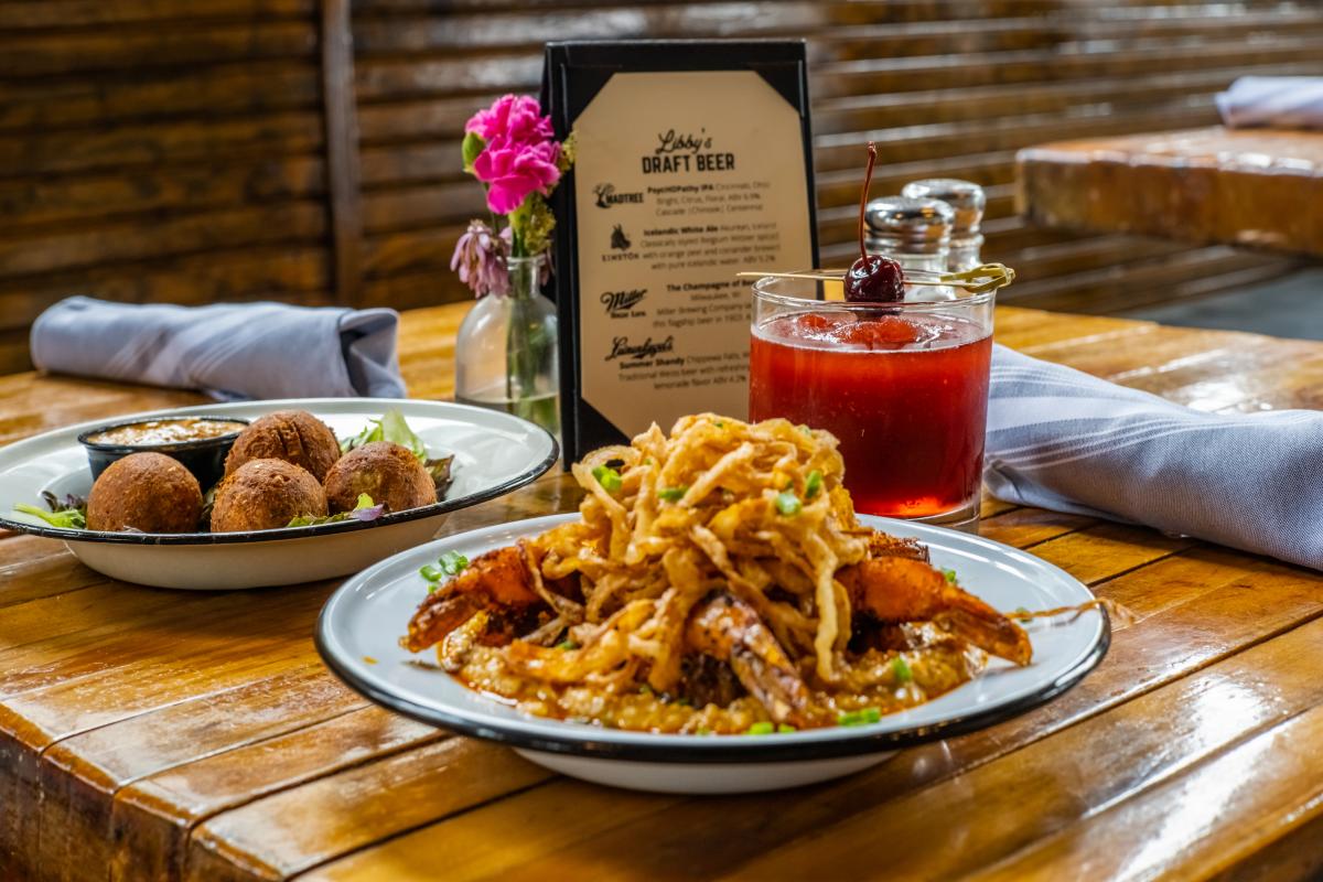 A plate of shrimp and grits, a plate of goetta hushpuppies and a cheerwine bourbon slush at Libby's Southern Comfort restaurant