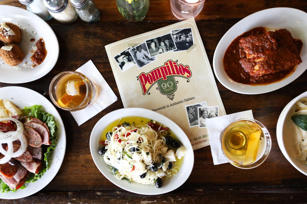 Pompilios menu surrounded by various cocktails, appetizers, and entrees.