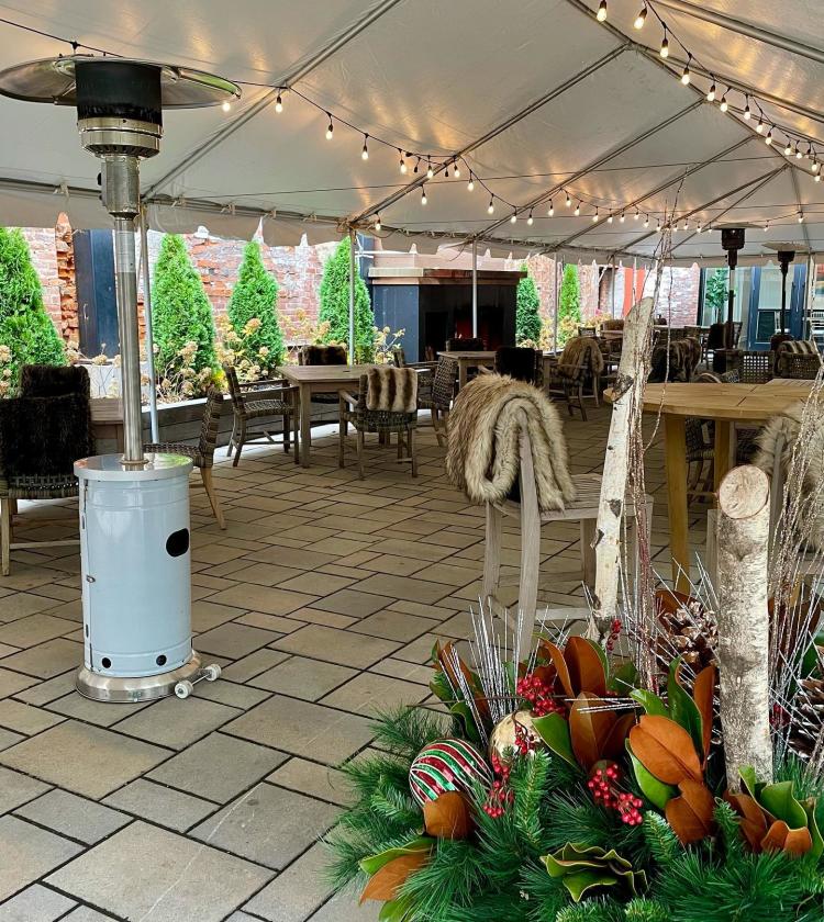 Tented patio with string lights, gas heaters, and faux furs at the tables of Coppin's restaurant