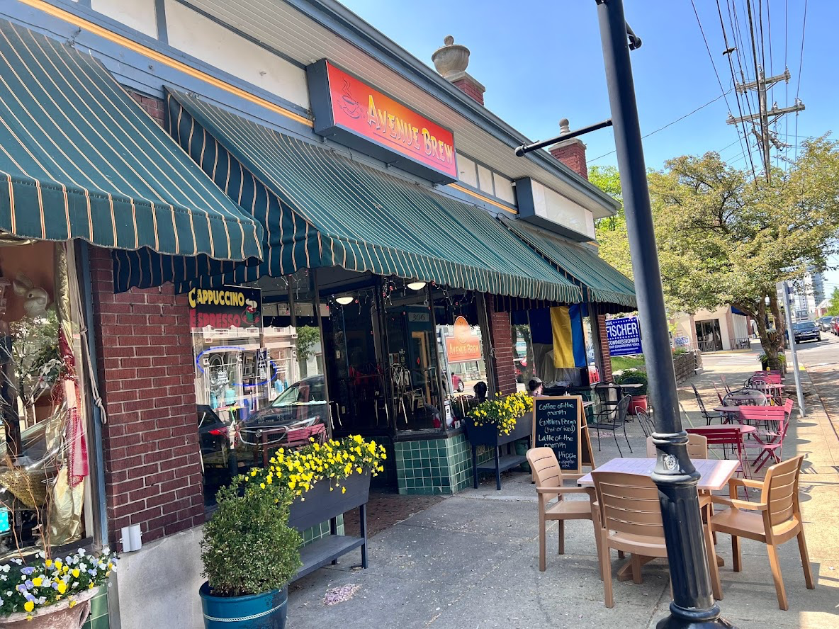 Image is of the outdoor facade of Avenue Brew with tables and chairs in front.