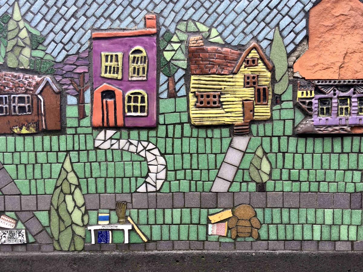 Closeup of a multi-colored mosaic showing houses and a street that's a public art work in Covington, Ky.