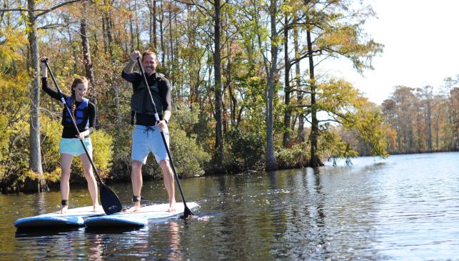 Two stand up paddleboarders on a waterway