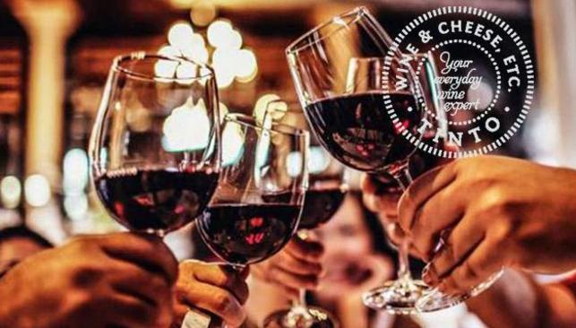 People clinking glasses of red wine to cheers, at Tinto Wine and Cheese