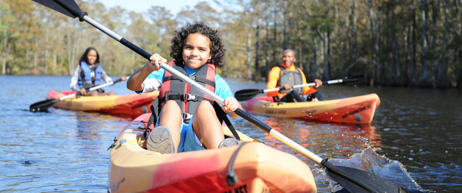 Three individuals on kayaks in the Northwest river