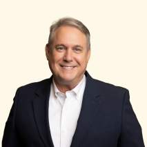 Headshot of Rick Lackland with a cream colored background
