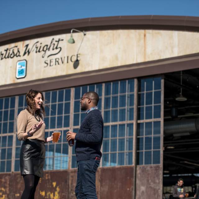 Couple drinking beer at the Curtis Wright Hangar
