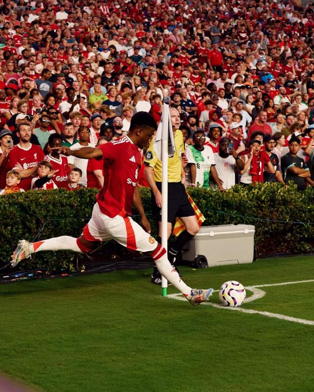 A soccer player runs toward a soccer ball to kick it for a corner kick