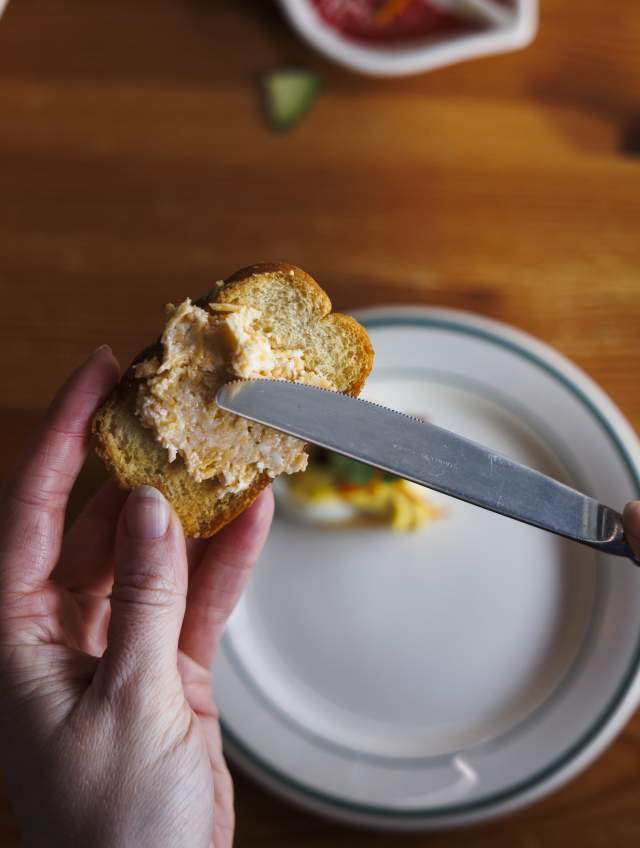 Overhead photo someone spreading pimento cheese on a cracker