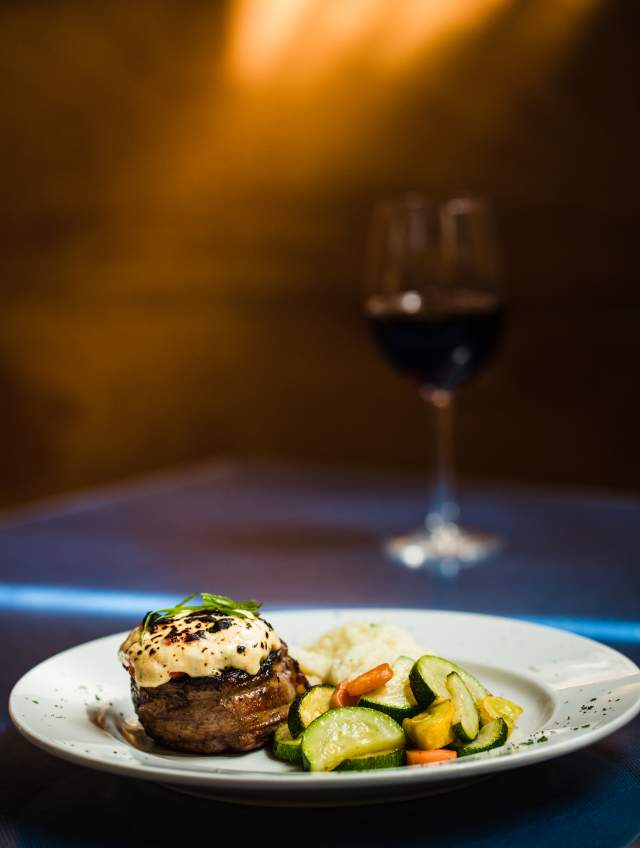 Steak topped with pimento cheese and a side of vegetables