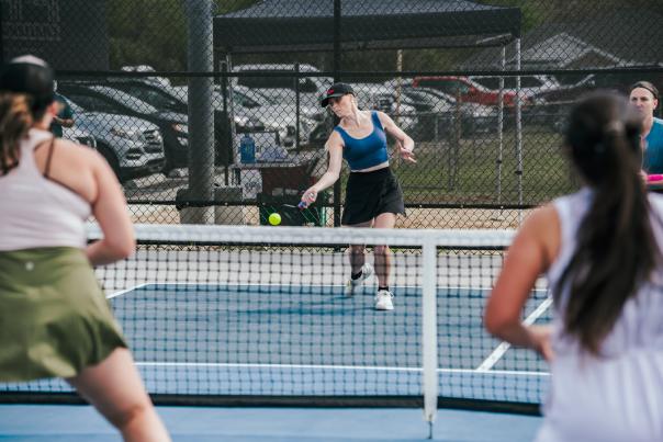 Women playing pickleball on an outdoor court