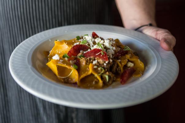 Chef holding pasta dish