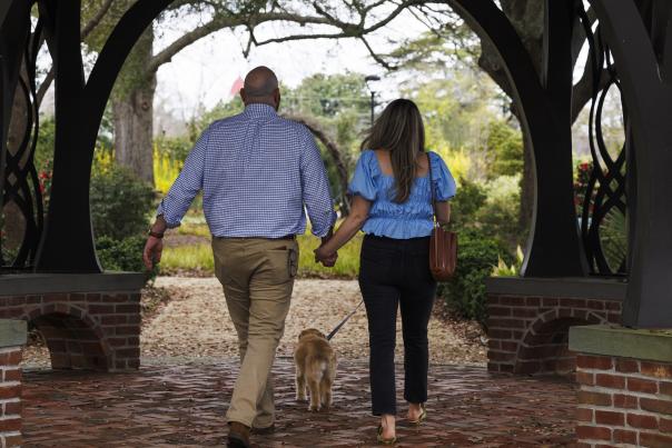 Man and woman couple holding hands and walking away from camera