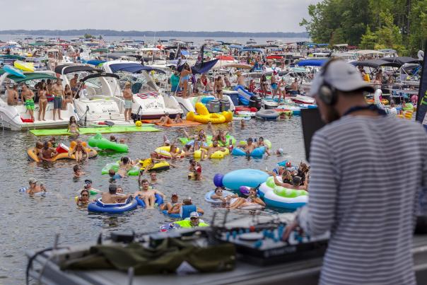 DJ playing music at a festival on a lake