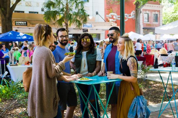 Five people standing at a street market