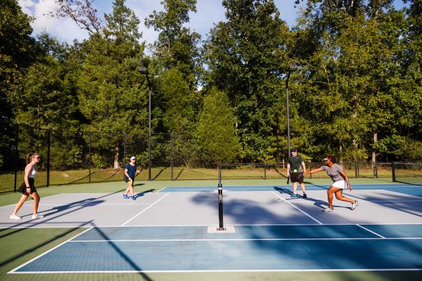 Four people play pickleball