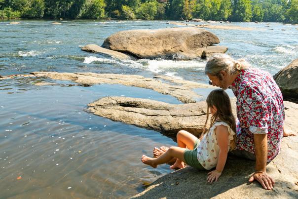 Father and daughter sitting on the banks of the Broad River