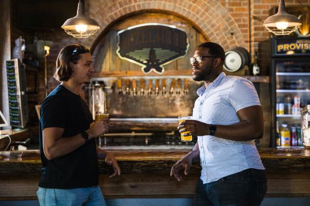 Two men drinking beer at a bar