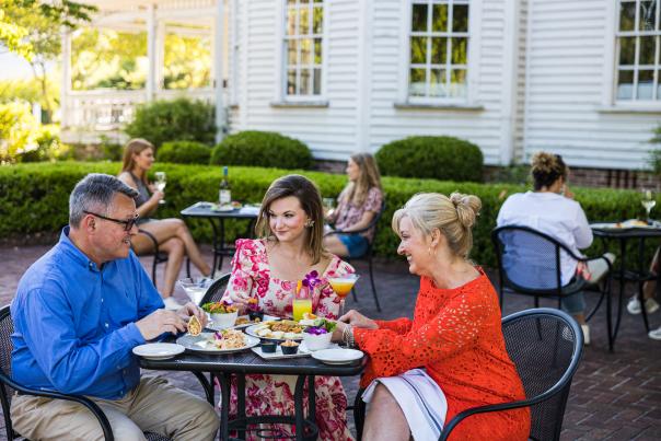 three people dining on a patio