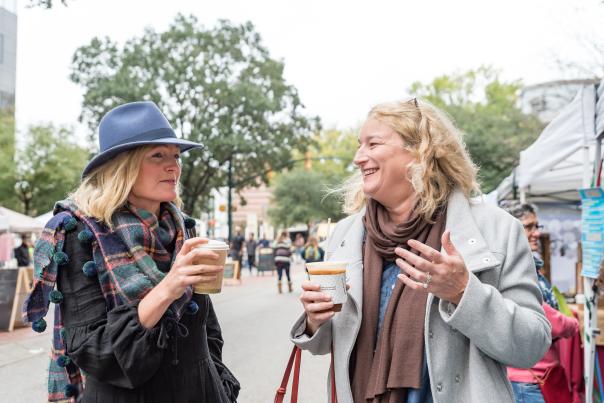 Two friends drinking coffee at Soda City Market