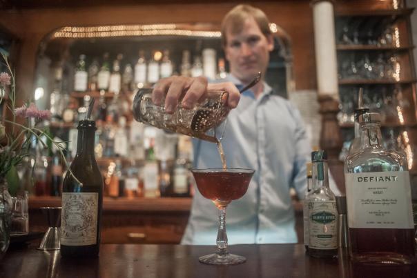 A downtown Columbia SC bartender pouring a whisky drink at the bar