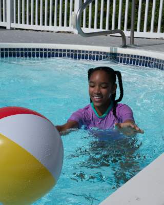 girl playing with beach ball in a pool