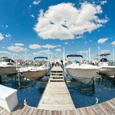 a boardwalk leading to boats parked at a dock