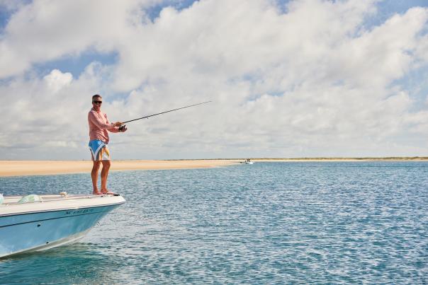 Man fishing off a bow of a boat