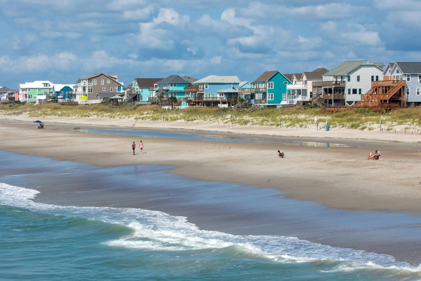 Aerial view of a sandy beach with ocean waves meeting the shoreline.