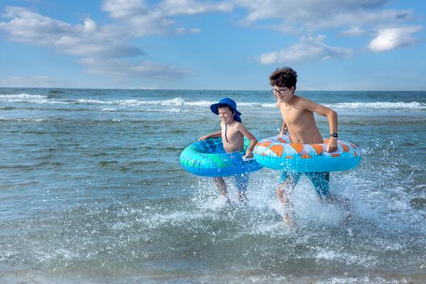 Kids with inner tubes in ocean