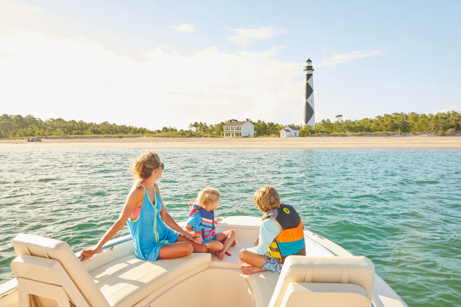 Family looking at lighthouse from boat