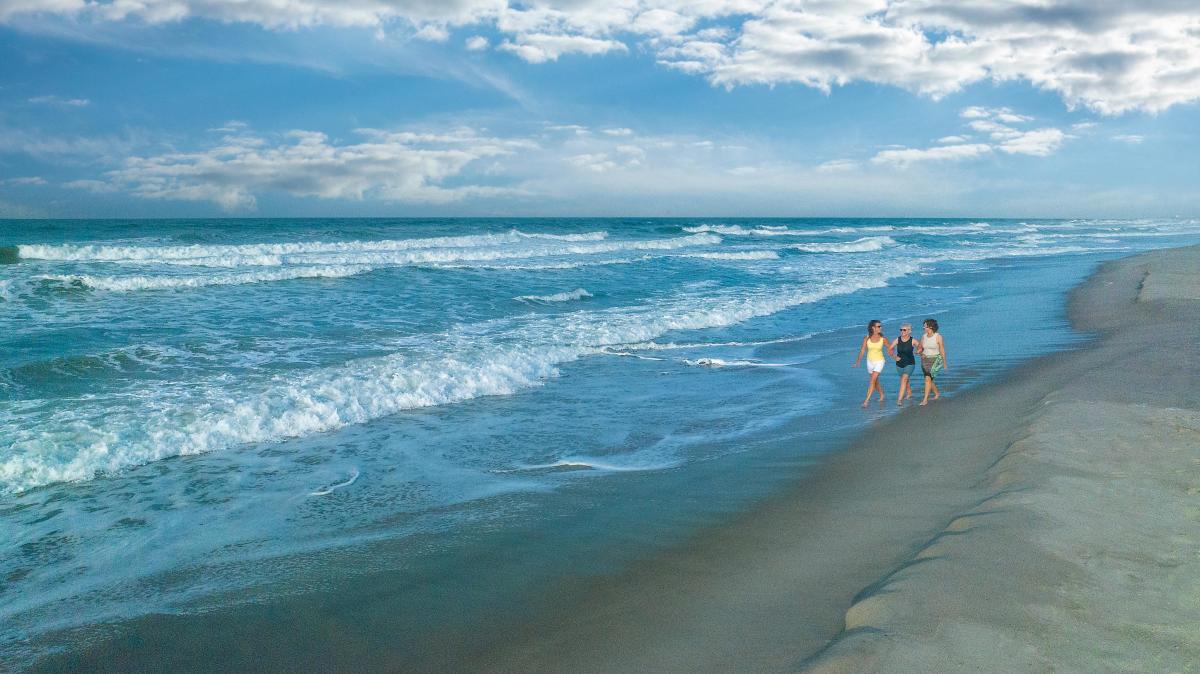 Ladies walking on the beach at sunrise