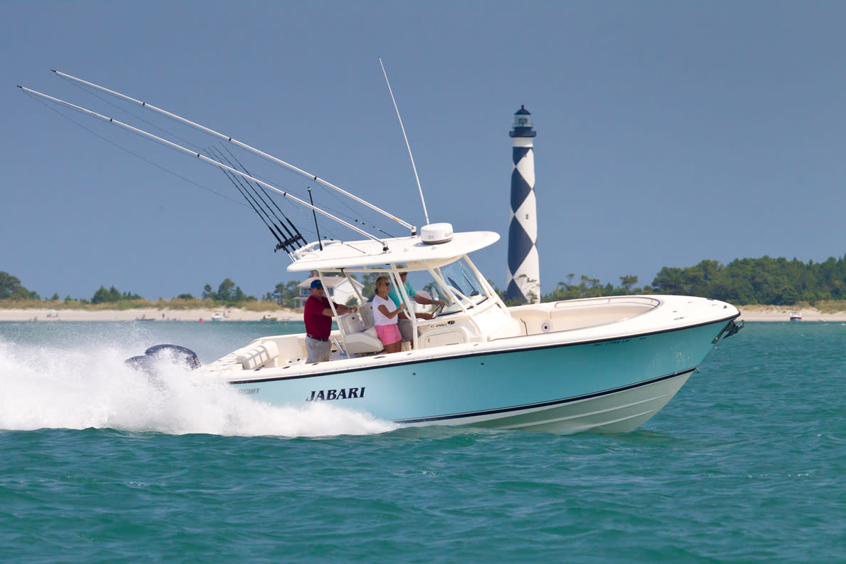 boat with lighthouse behind it