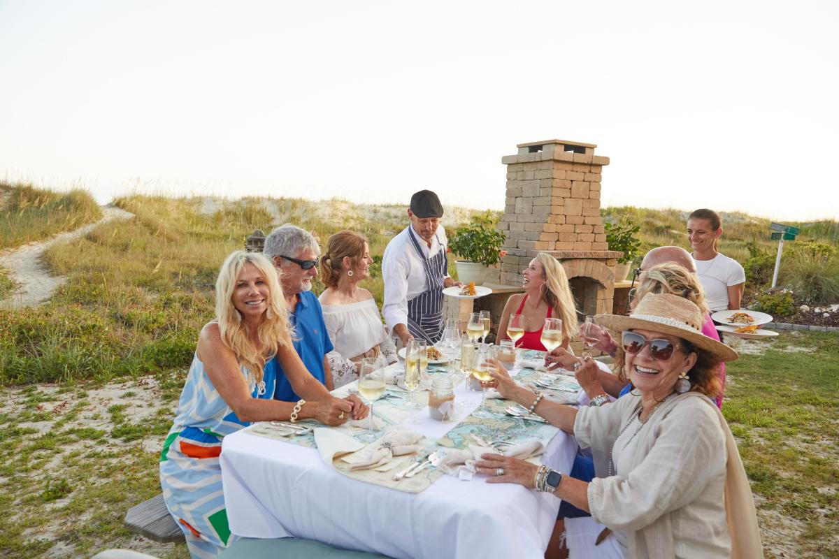 Family outside dining at beach house